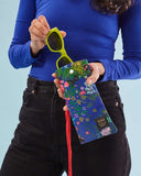 Funda de gafas o móvil con estampado original hecha de tejidos de botellas recicladas, estampado Flores Nuria, diseño original de pequeñas plantas y flores de colores sobre un fondo azul, moda sostenible