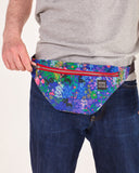 bolso-riñonera nuria flores con cierre delantero, cinta regulable, estampado original de flores sobre un fondo azul, moda lentita, moda española, marca unisex