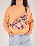 bolso-riñonera pieles con cierre delantero, cinta regulable, estampado original de puños en alto con diferentes tonos, moda lentita, moda española, marca unisex