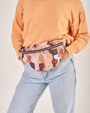 bolso-riñonera pieles con cierre delantero, cinta regulable, estampado original de puños en alto con diferentes tonos, moda lentita, moda española, marca unisex